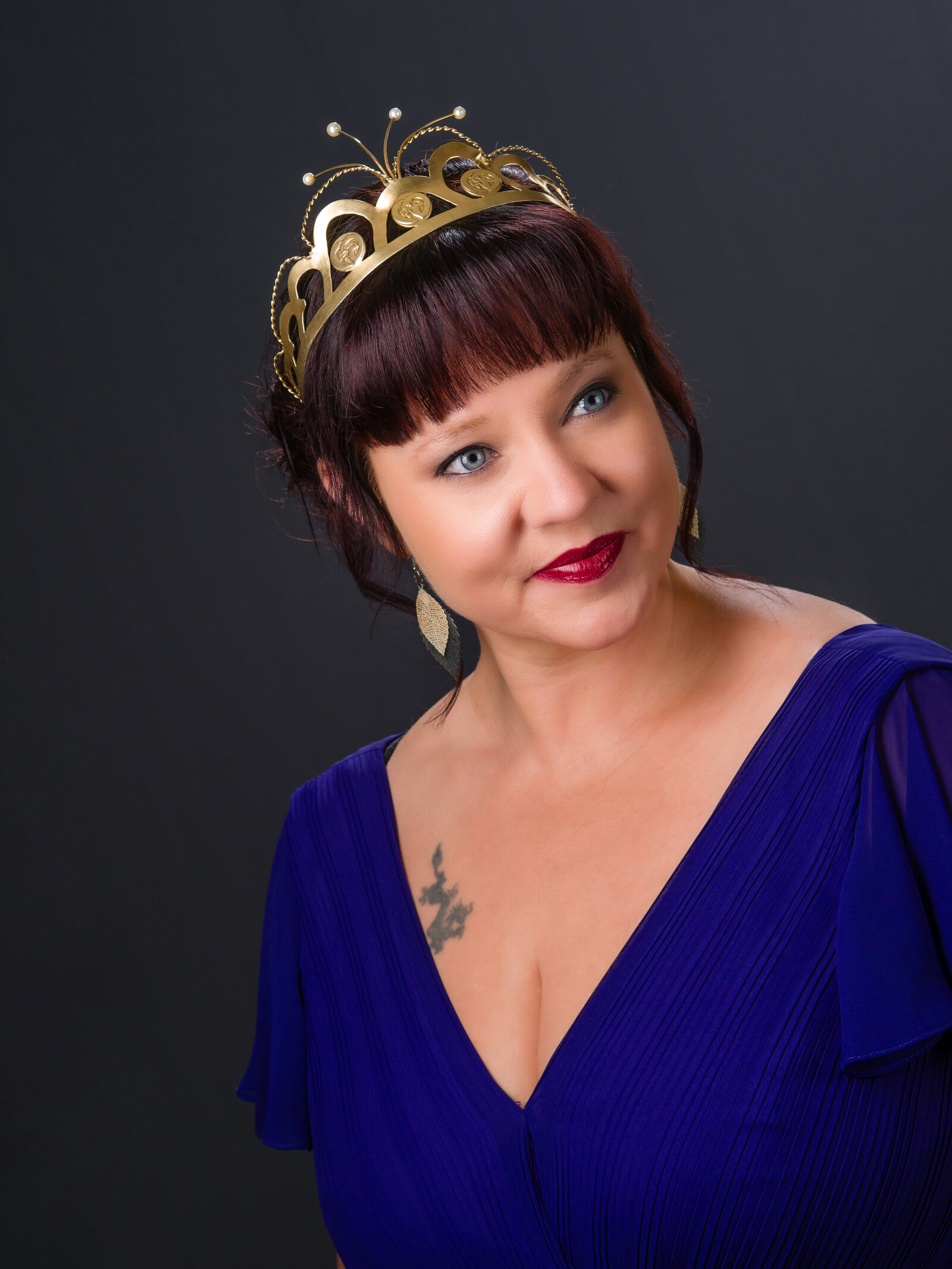 Hanna Hirvonen tummassa iltapuvussa katsomassa kameraan lämpimässä valossa.